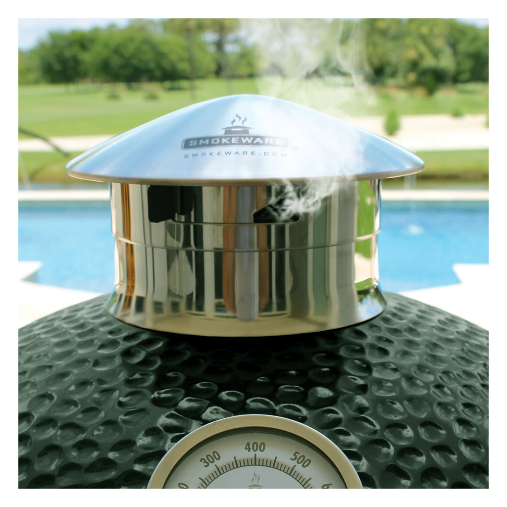 Side view of a Smokeware Cap on a Big Large Green EGG kamado grill. Side vent is open and emitting smoke. Cap fits Medium, Large, XL and 2xl Big Green EGG grills.