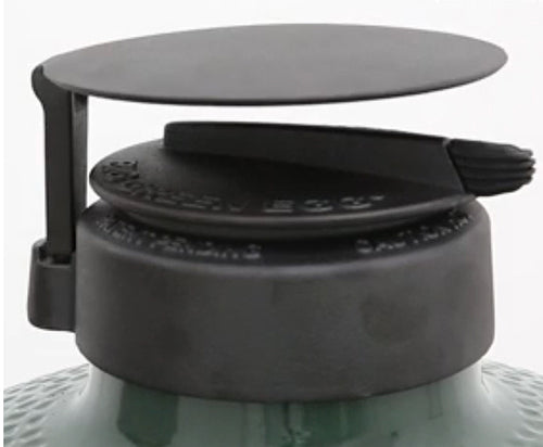 Big Green EGG rEGGulator and Rain Cap shown atop a Big Green EGG. The rEGGulator controls airflow through the grill  via a top slider plate. The removable Rain Cap, cantilever design, sits atop the rEGGulator and keeps rain out.   REGGulator and Rain Cap available for all Big Green EGG grills except the Mini EGG.